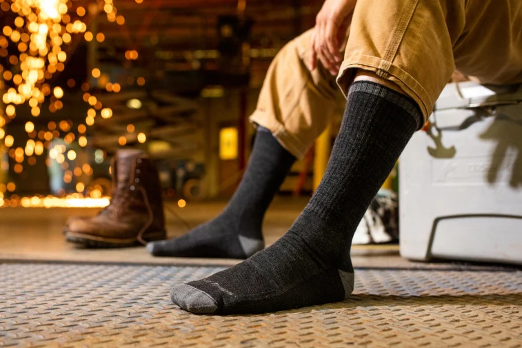 Shop Midweight Socks - feet wearing charcoal gray work socks, about to put on work boots